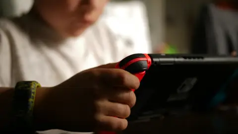 Un niño jugando a videojuegos Un niño jugando a videojuegos