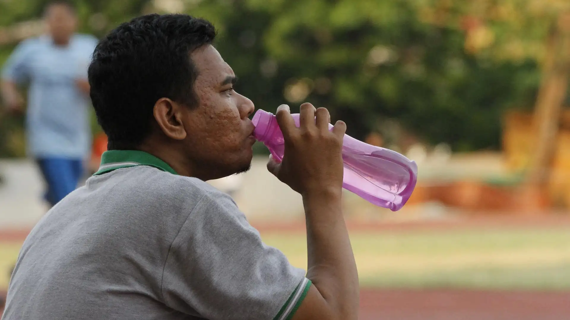 Un hombre bebe agua para hidratarse Un hombre bebe agua para hidratarse