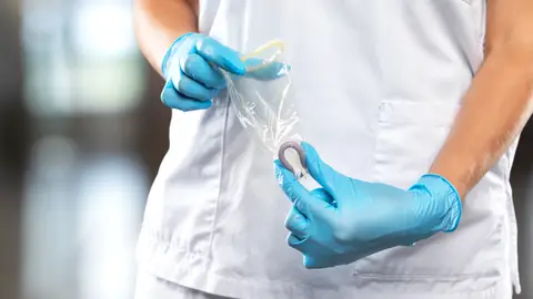 Sanitario mostrando preservativo femenino Sanitario mostrando preservativo femenino