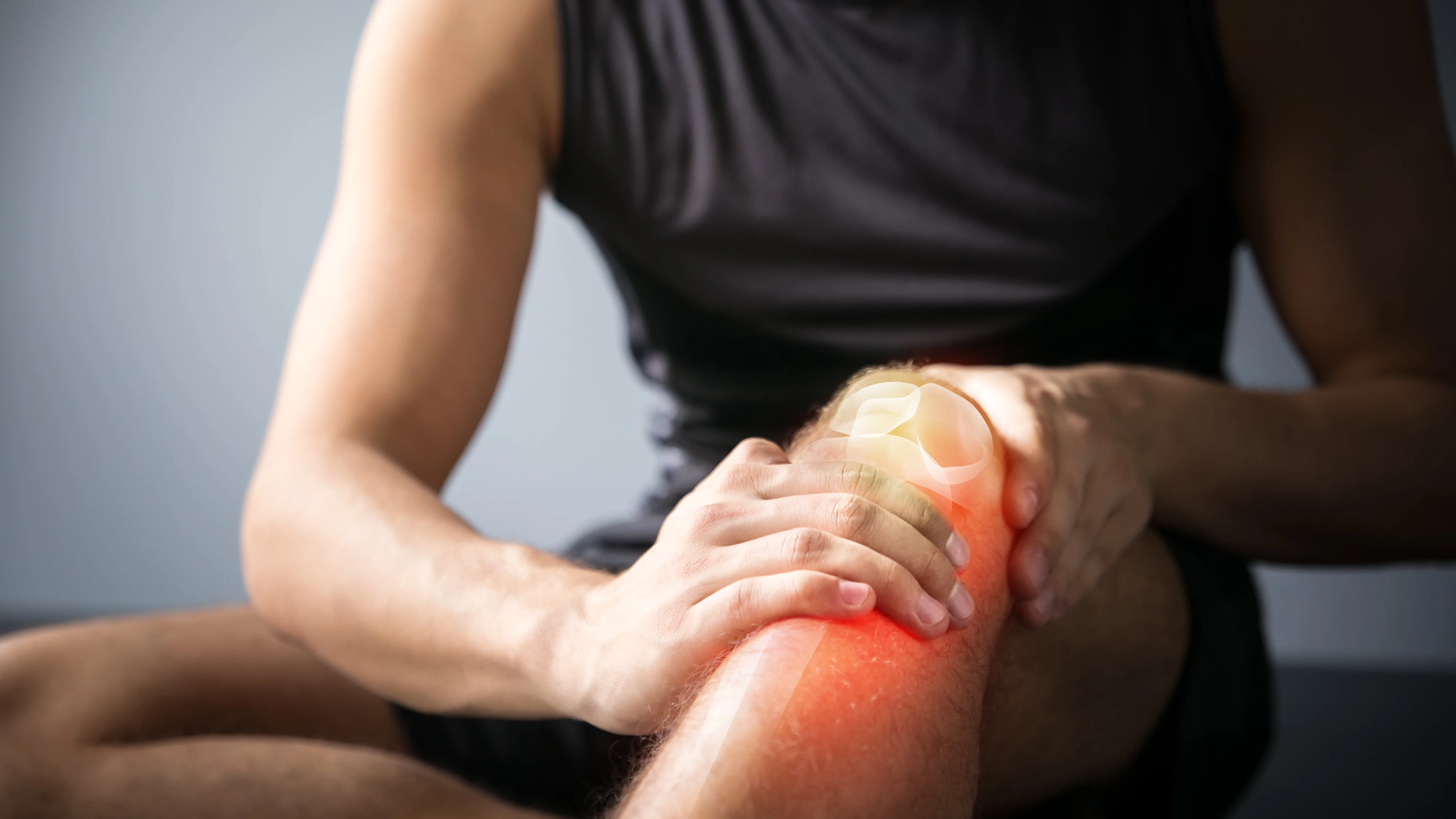 Plano corto de un varón que se sujeta la rodilla lesionada Plano corto de un varón que se sujeta la rodilla lesionada