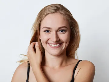 Plano medio de mujer joven sonriendo con hoyuelos en las mejillas Plano medio de mujer joven sonriendo con hoyuelos en las mejillas