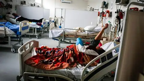 Un hospital con varias personas enfermas en su interior Un hospital con varias personas enfermas en su interior