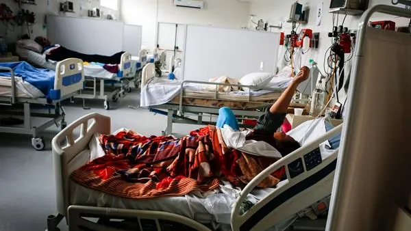 Un hospital con varias personas enfermas en su interior Un hospital con varias personas enfermas en su interior