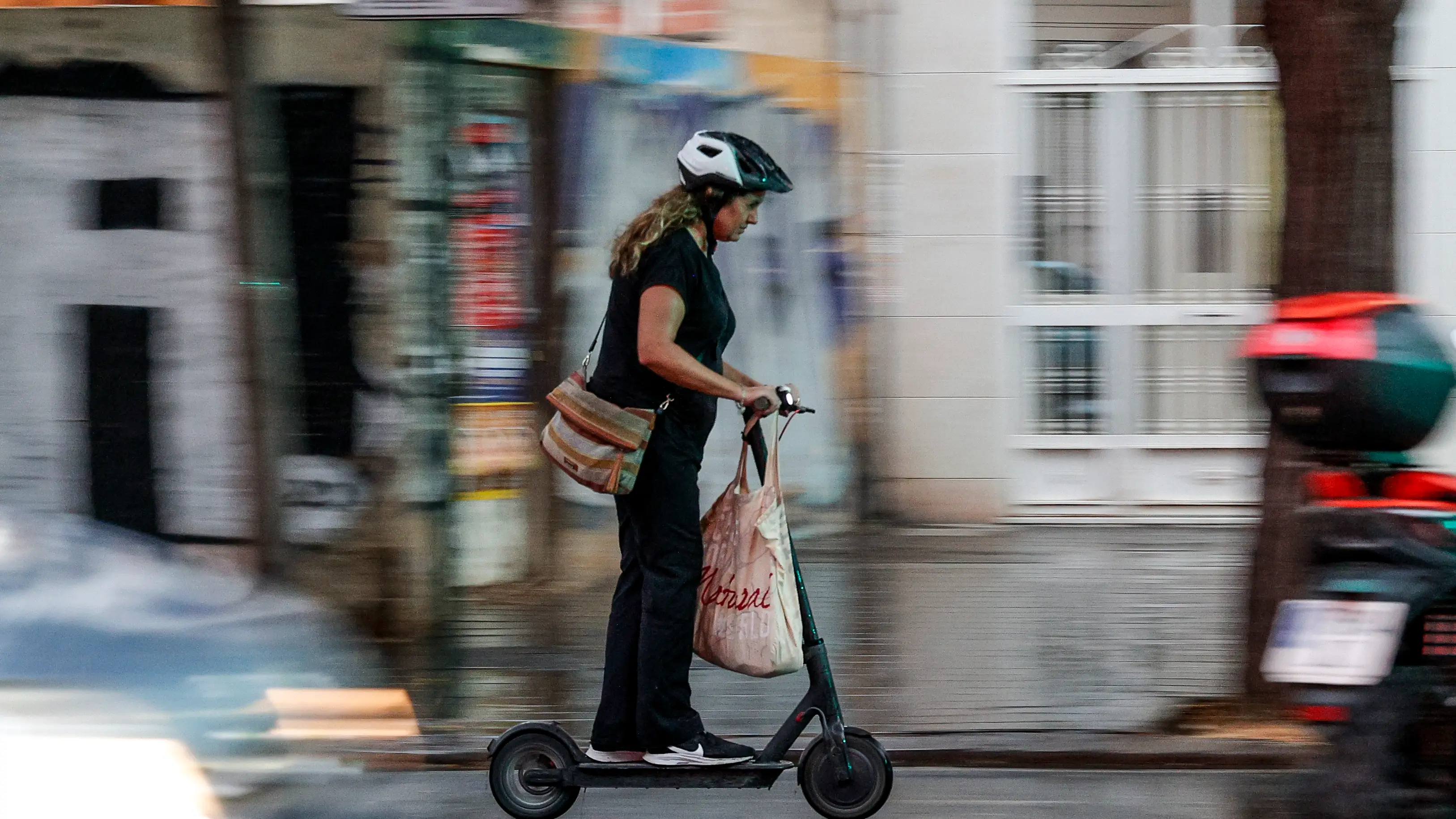 Imagen de archivo de una mujer en un patinete eléctrico Imagen de archivo de una mujer en un patinete eléctrico