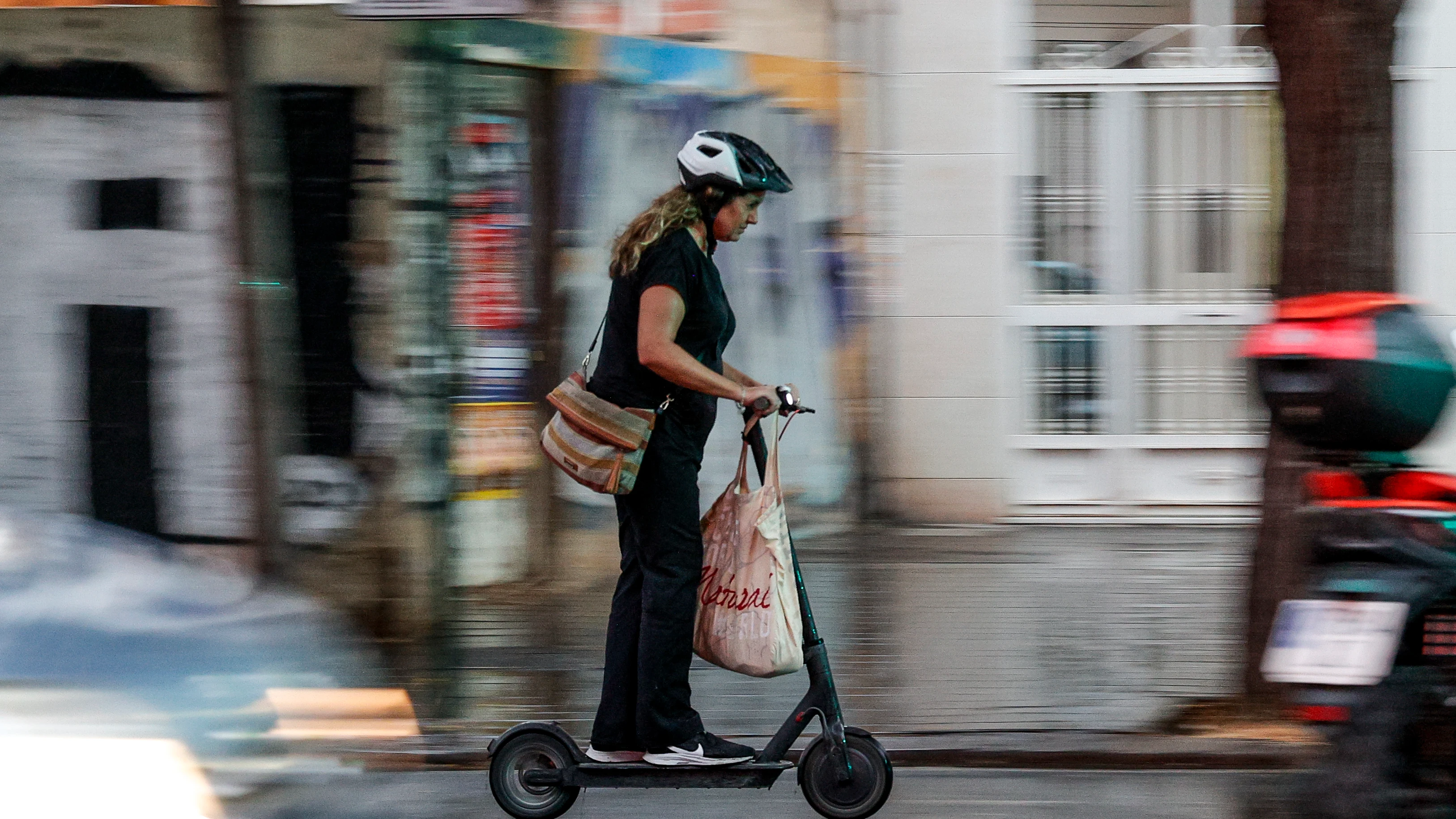 Imagen de archivo de una mujer en un patinete eléctrico Imagen de archivo de una mujer en un patinete eléctrico