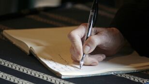 Un hombre fisrmando  un testamento