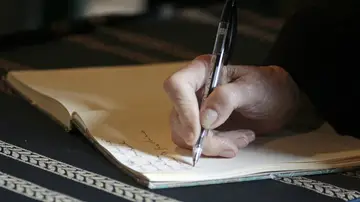 Un hombre fisrmando un testamento Un hombre fisrmando un testamento