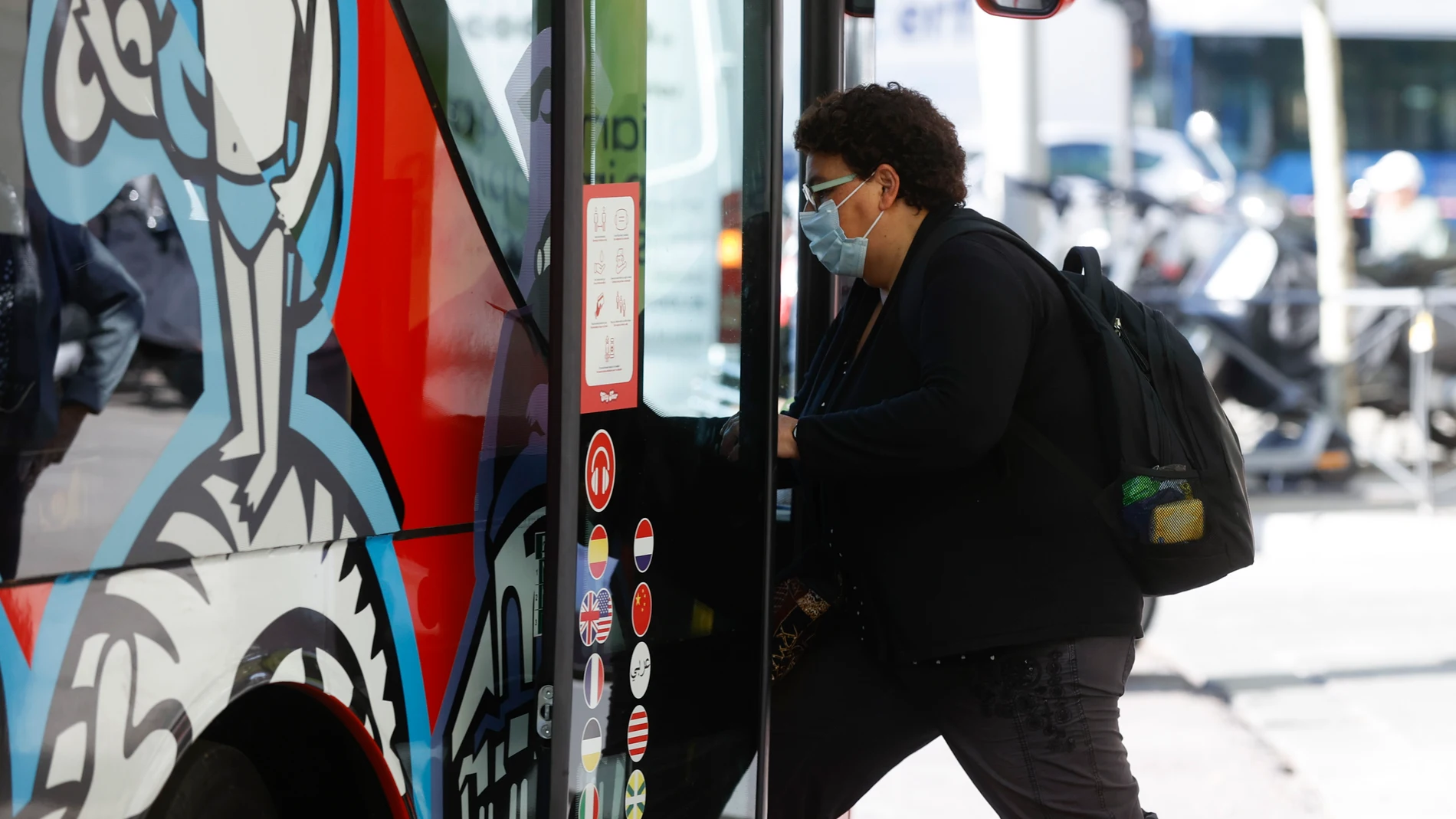 Un hombre se sube a un autobús en Madrid con la mascarilla puesta
