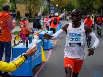 Claus pasándole el agua con sales a Kipchoge Claus pasándole el agua con sales a Kipchoge