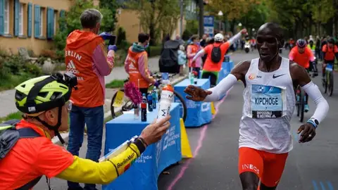 Claus pasándole el agua con sales a Kipchoge Claus pasándole el agua con sales a Kipchoge