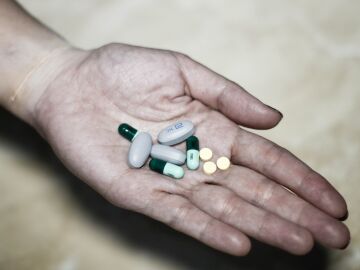 Mujer sosteniendo varios tipos de pastillas