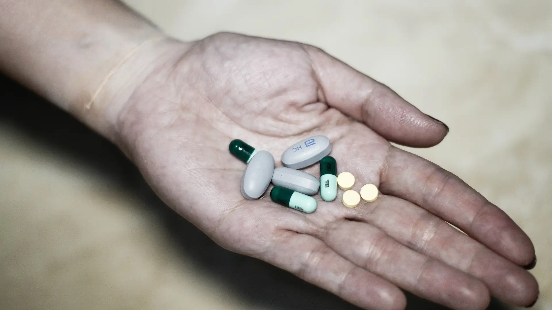 Mujer sosteniendo varios tipos de pastillas