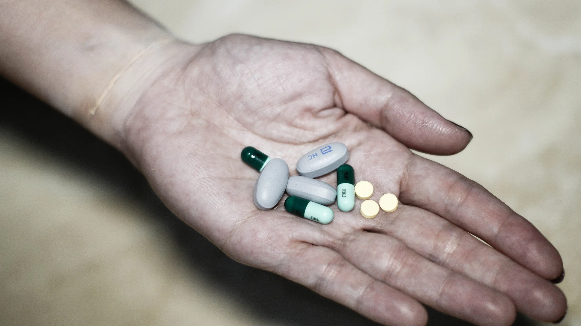 Mujer sosteniendo varios tipos de pastillas Mujer sosteniendo varios tipos de pastillas