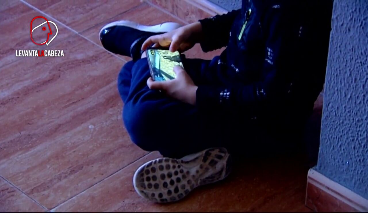 Niño juega con el móvil sentado
