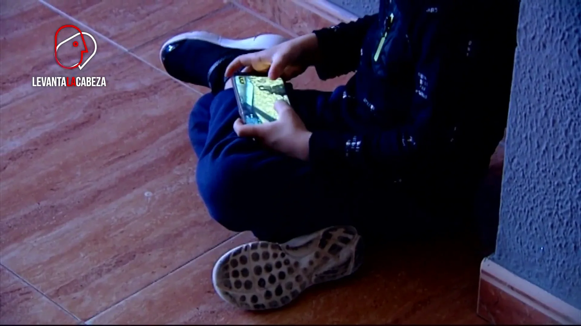 Niño juega con el móvil sentado Alicante