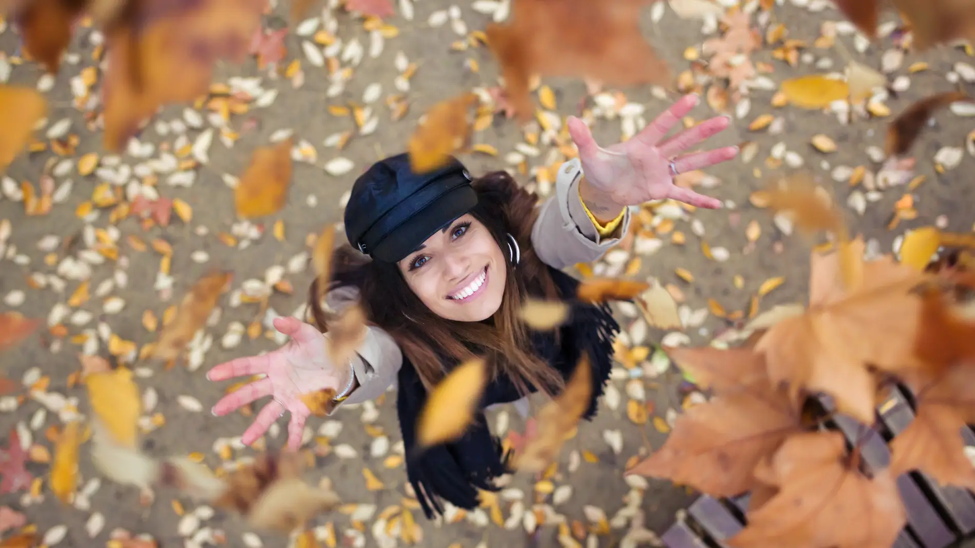 Una chica alegre entre las hojas de otoño.