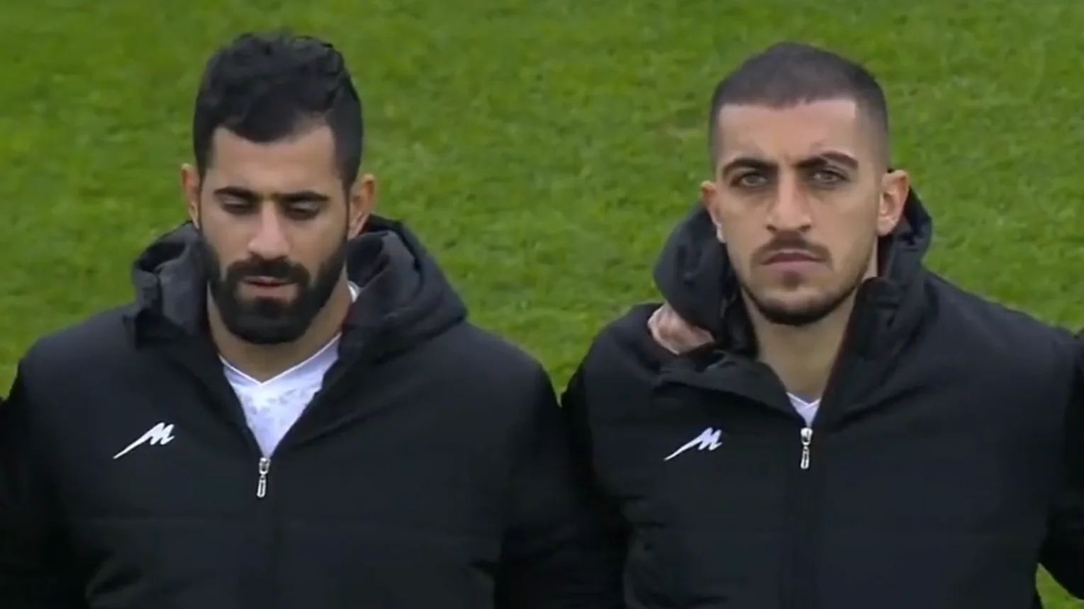 Los futbolistas tapan el escudo iraní mientras suena el himno de su país Los futbolistas tapan el escudo iraní mientras suena el himno de su país