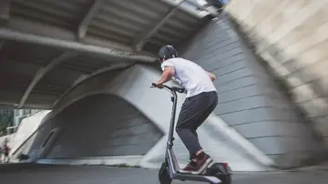 Un joven con un patinete eléctrico Un joven con un patinete eléctrico