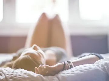 Imagen de archivo de una mujer tumbada en la cama Imagen de archivo de una mujer tumbada en la cama