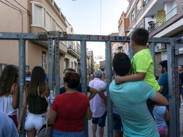 Personas apoyadas en una barrera de seguridad en un festejo taurino