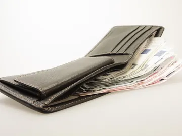Una cartera llena de dinero Una cartera llena de dinero