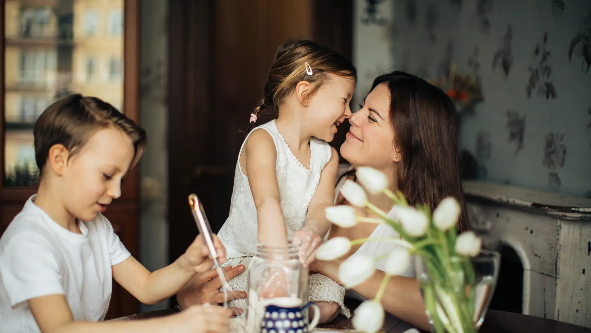 Una madre cocina junto a sus hijos.