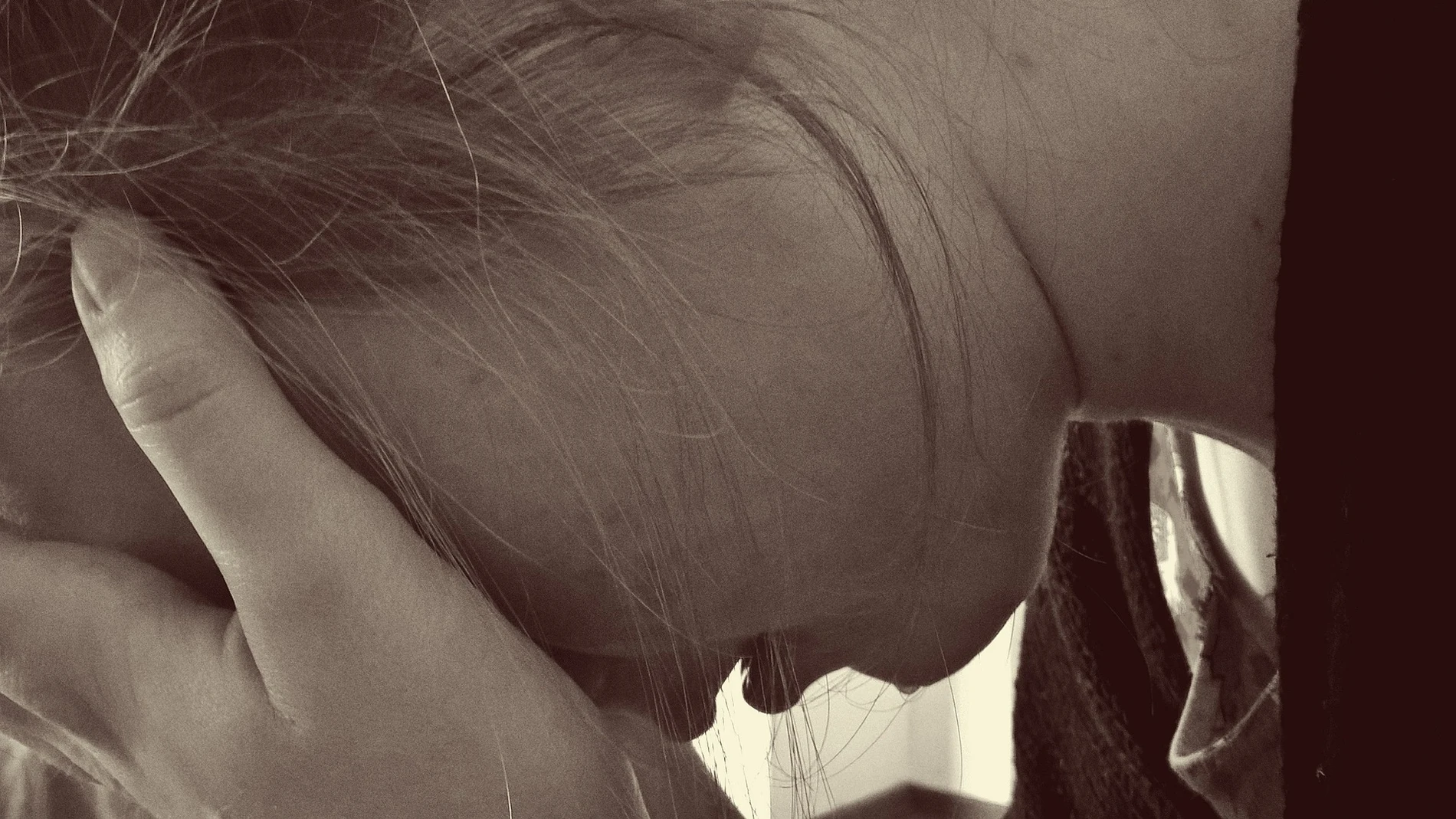 Imagen de una joven cabizbaja y llorando