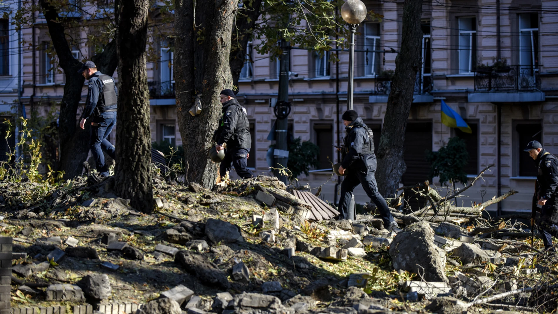 Agentes de policía caminan entre los escombros tras un bombardeo en el centro de Kiev