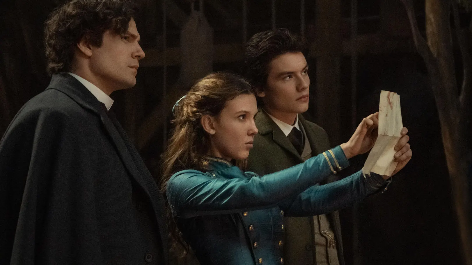 Henry Cavill as Sherlock Holmes, Millie Bobby Brown as Enola Holmes, Louis Partridge as Tewkesbury 