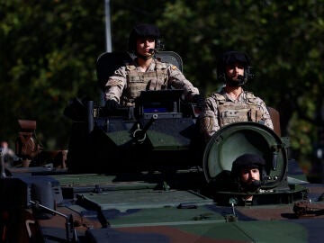Varios soldados a bordo de un vehículo blindado participan en el desfile del Día de la Fiesta Nacional