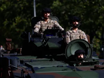 Varios soldados a bordo de un vehículo blindado participan en el desfile del Día de la Fiesta Nacional Varios soldados a bordo de un vehículo blindado participan en el desfile del Día de la Fiesta Nacional