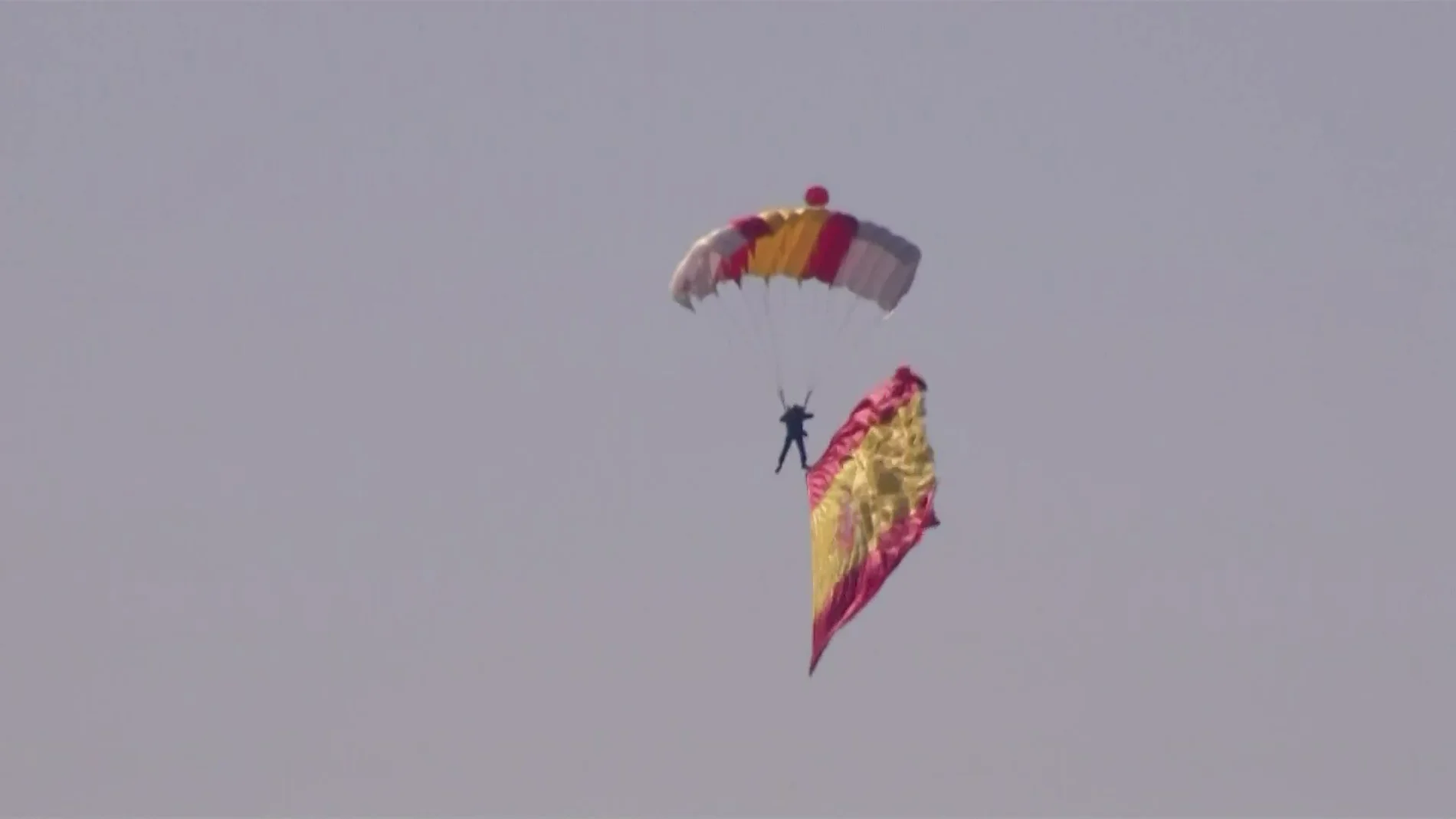 El paracaidista, con la bandera española, durante el Día de la Hispanidad