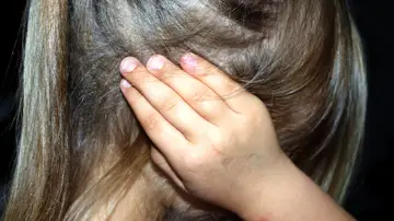 Niña tapándose los oídos Niña tapándose los oídos