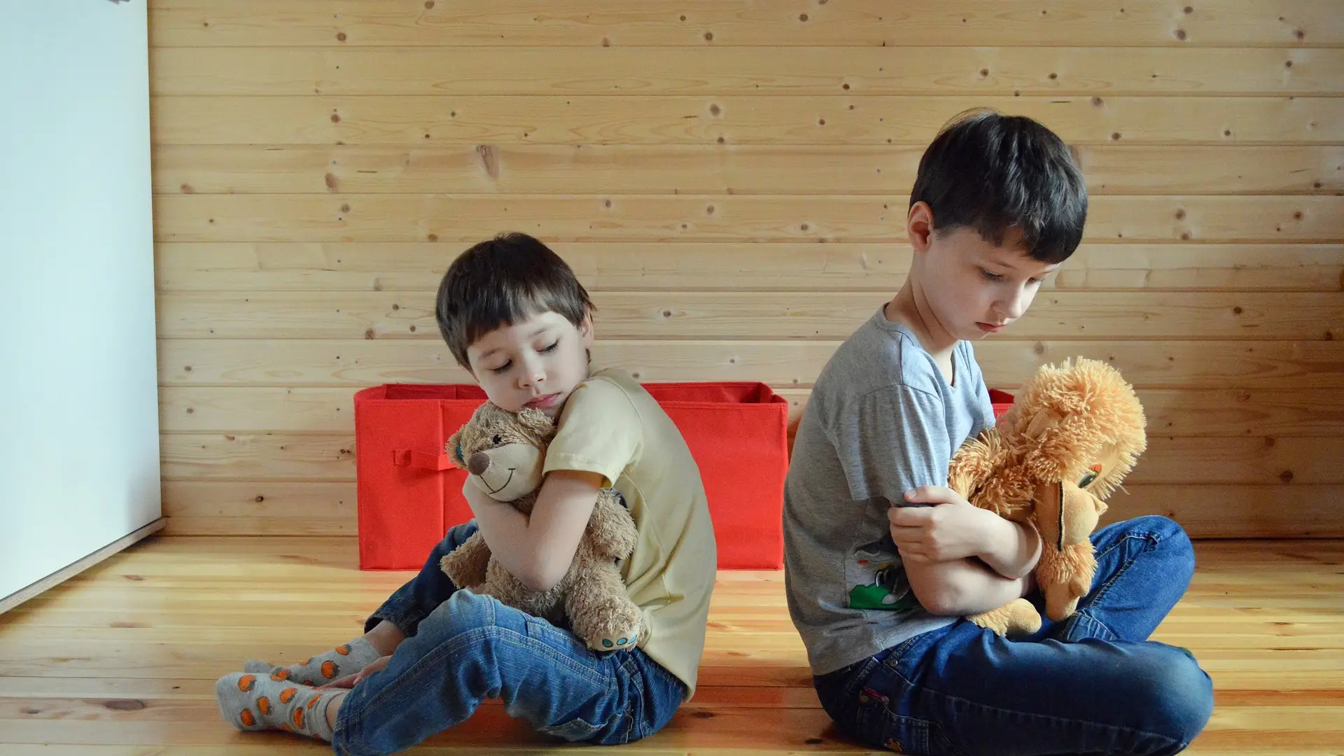 Imagen de dos ni&ntilde;os sentados en el suelo y en silencio