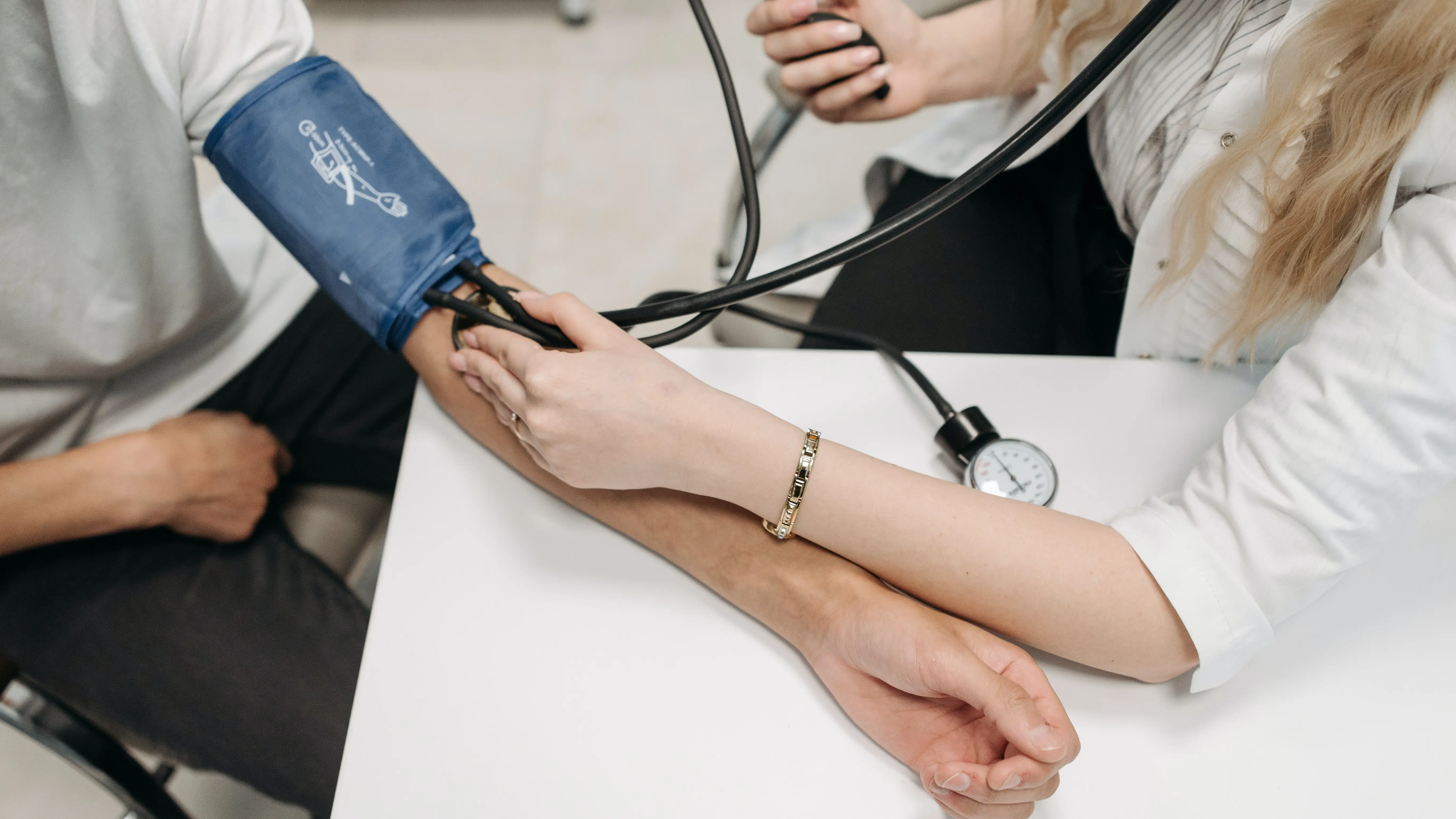 Una doctora toma la tensión a un paciente Una doctora toma la tensión a un paciente