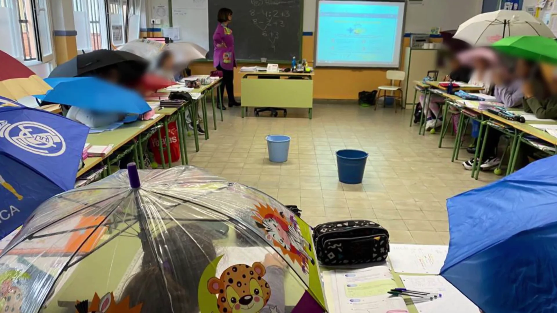 Los alumnos del centro con paraguas en clase Los alumnos del centro con paraguas en clase