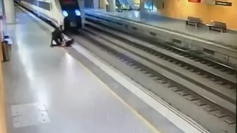 Dos agentes de la policía salvan la vida de una mujer a punto de saltar a las vías del tren Dos agentes de la policía salvan la vida de una mujer a punto de saltar a las vías del tren