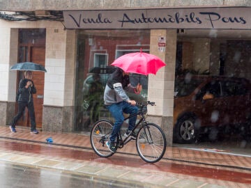 Viandantes se cubren con paraguas en las calles de Mahón, Menorca