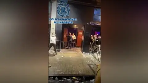El momento en que el detenido lanza una valla a los porteros El momento en que el detenido lanza una valla a los porteros