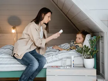 Una madre mide la temperatura a su hijo. Una madre mide la temperatura a su hijo.