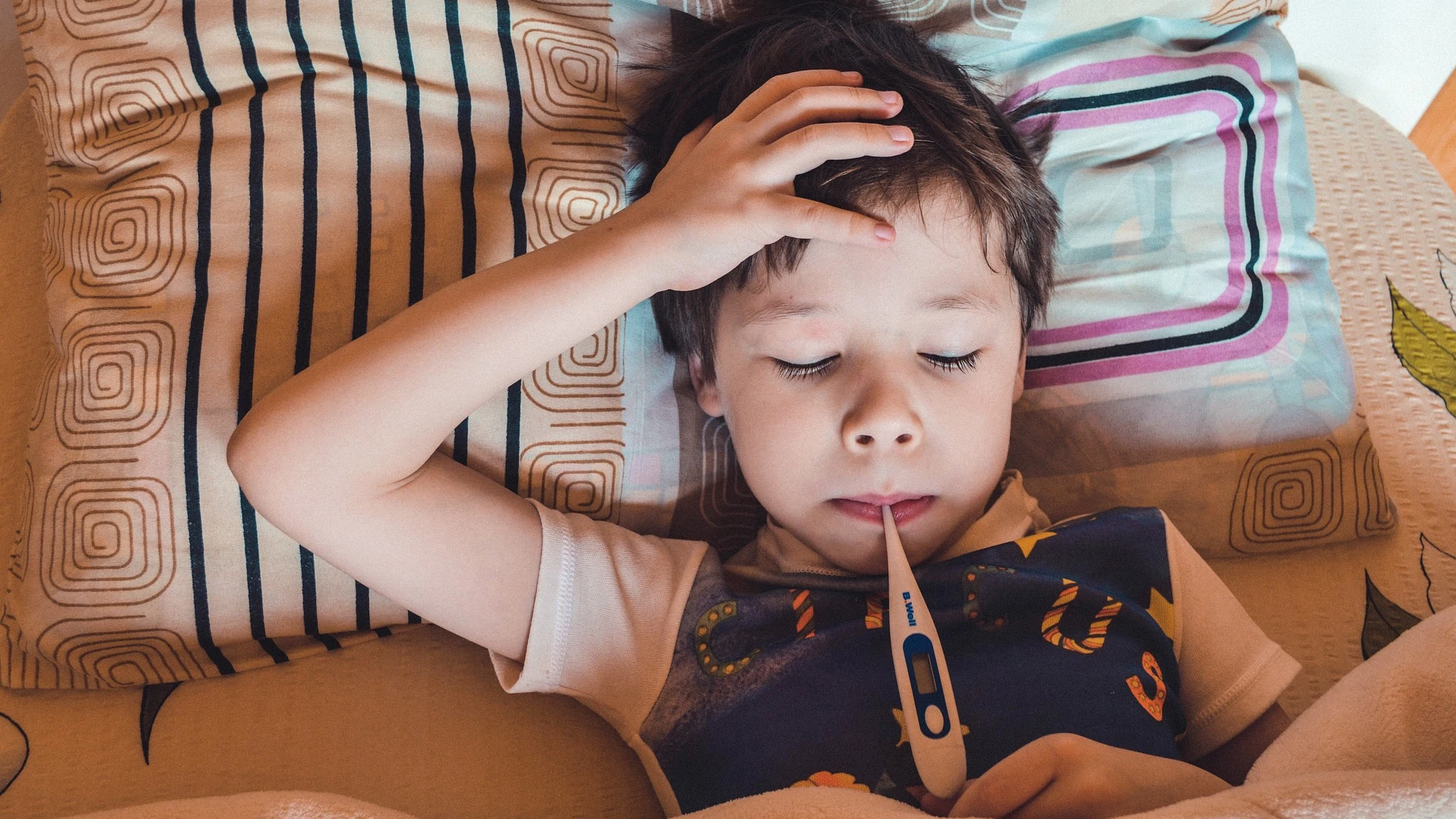 Imagen de recurso de un niño tomándose la temperatura Imagen de recurso de un niño tomándose la temperatura