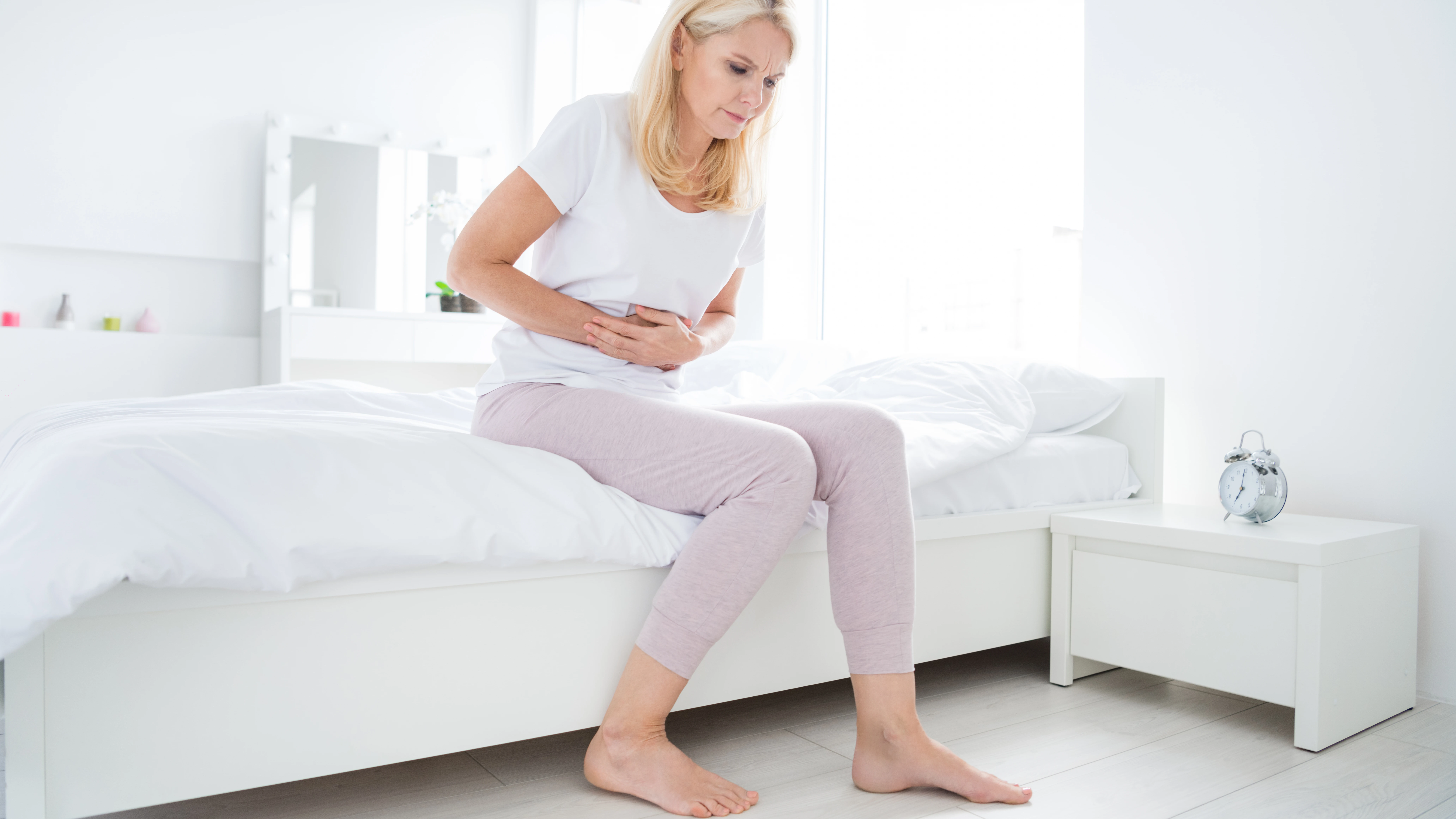 Mujer de mediana edad aquejándose de dolor abdominal.