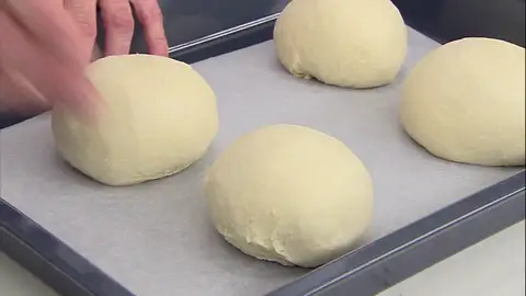 Redondea cuatro porciones y ponlas sobre la bandeja de horno Redondea cuatro porciones y ponlas sobre la bandeja de horno