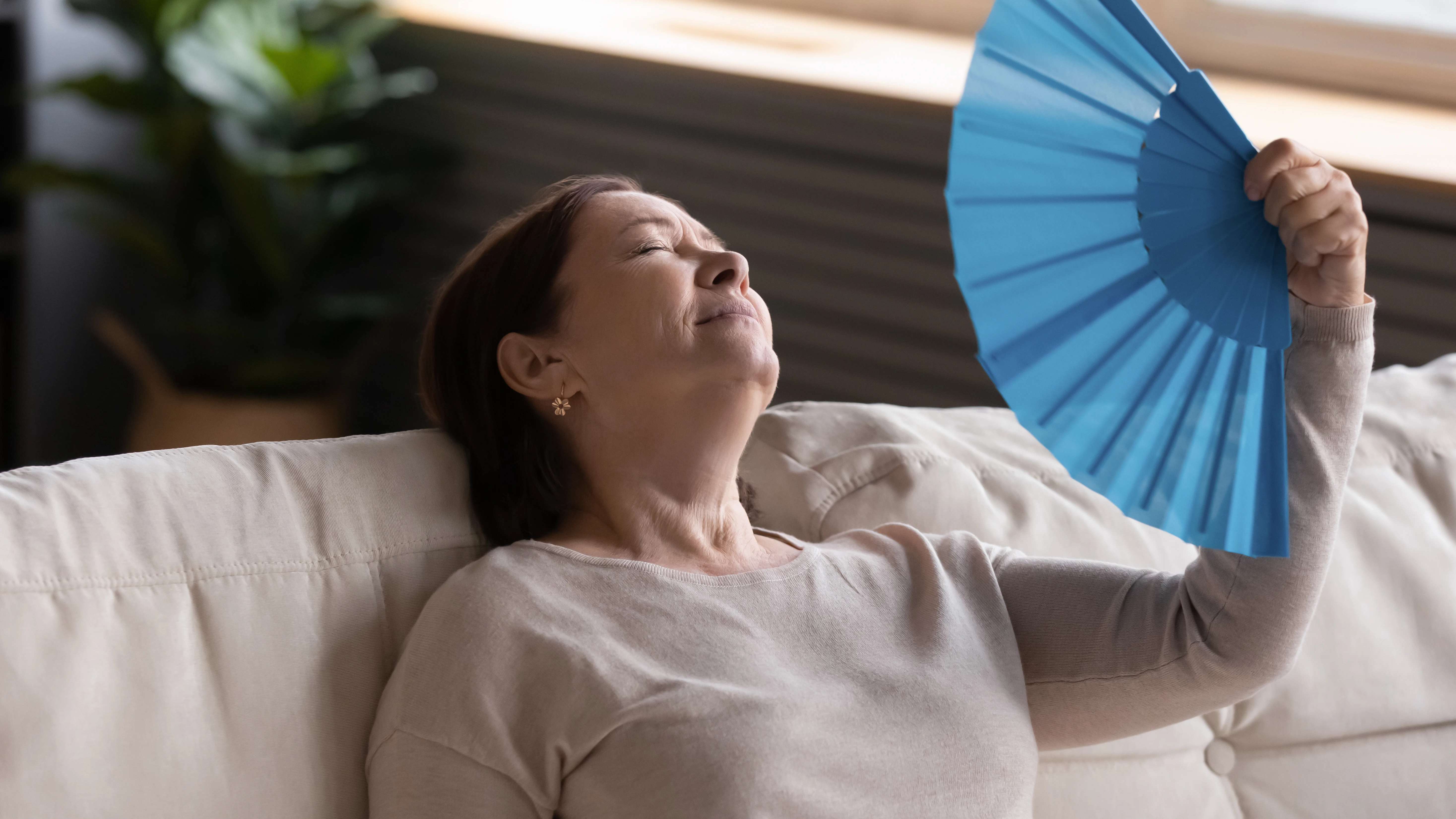 Mujer de edad madura abanic&aacute;ndose