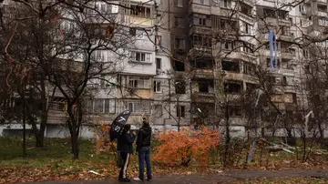 Ucranianos delante de un edificio dañado por bombas rusas en Jersón. Ucranianos delante de un edificio dañado por bombas rusas en Jersón.