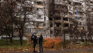 Ucranianos delante de un edificio dañado por bombas rusas en Jersón.