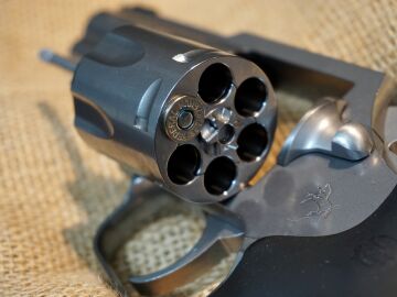 Imagen de un revólver con una bala en su interior