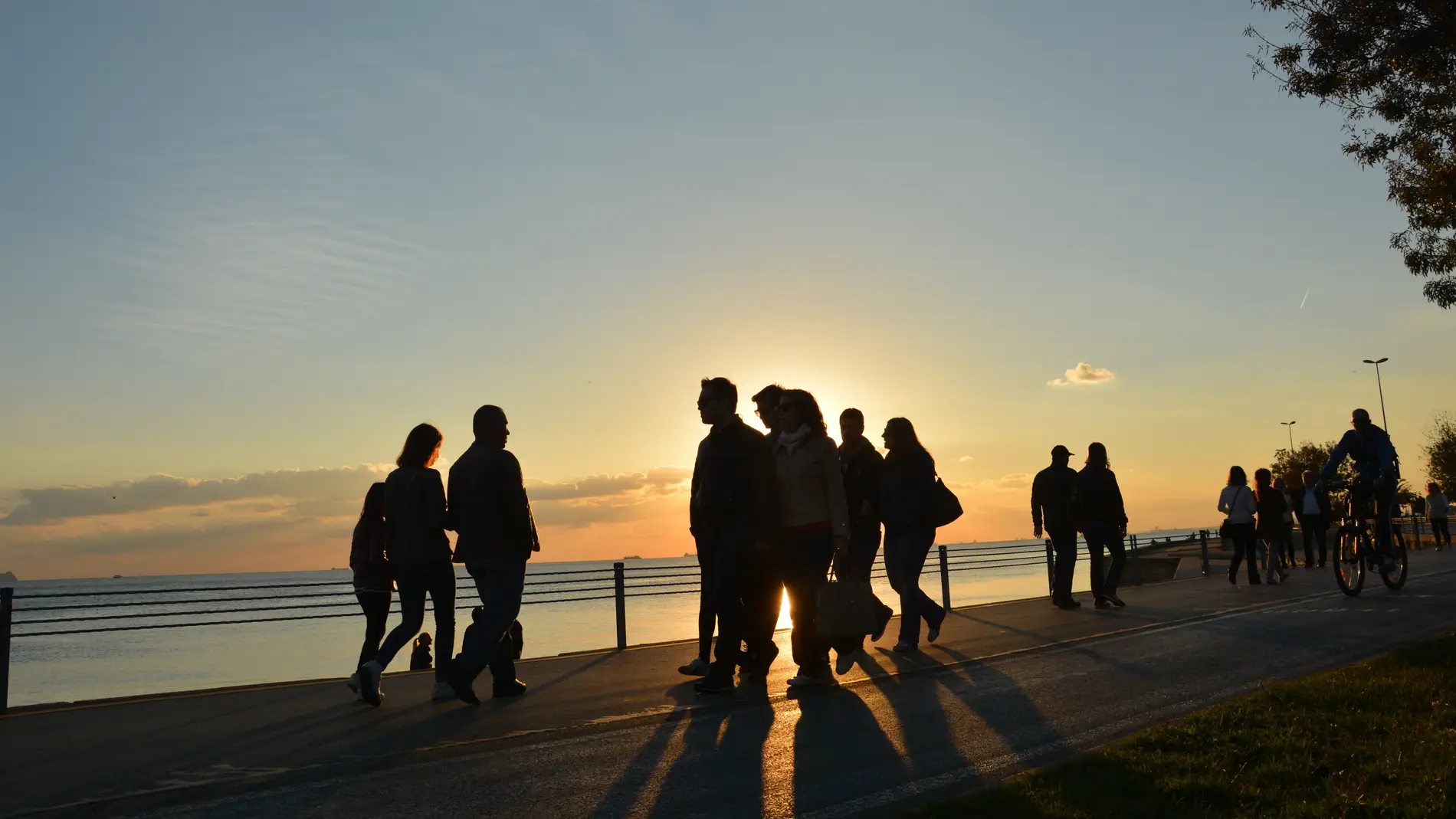 Familias y parejas paseando al atardecer.