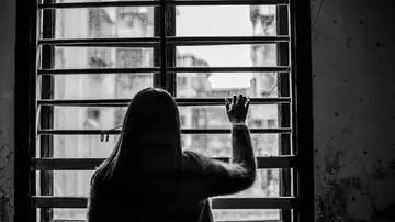 Una mujer mirando por la ventana Una mujer mirando por la ventana
