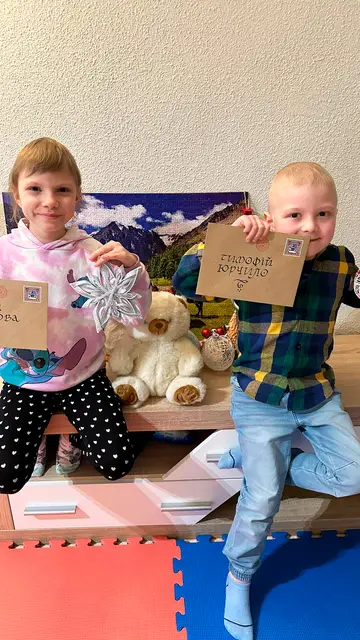 Dos niños ucranianos enfermos posan con sus cartas de Papá Noel